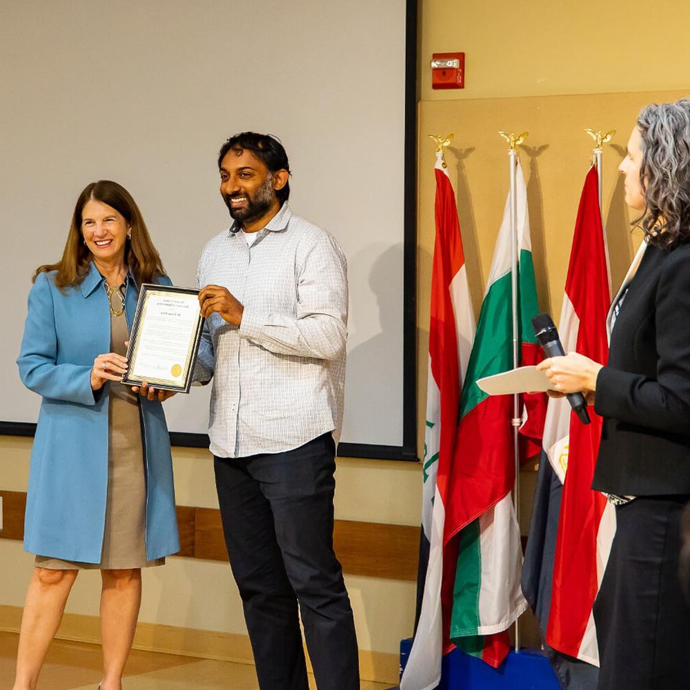 Younus Mirza, left, receives award from SU president, Tracy Fitzsimmons